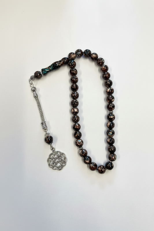 Brun iriserad tasbih med silverdetaljer och keltisk knutberlock på vit bakgrund